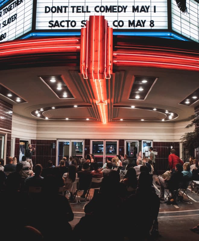 a comedy show taking place under a movie theater marquee